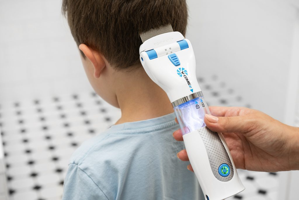 nuoren pojan niskaa kammataan täi-imurilla